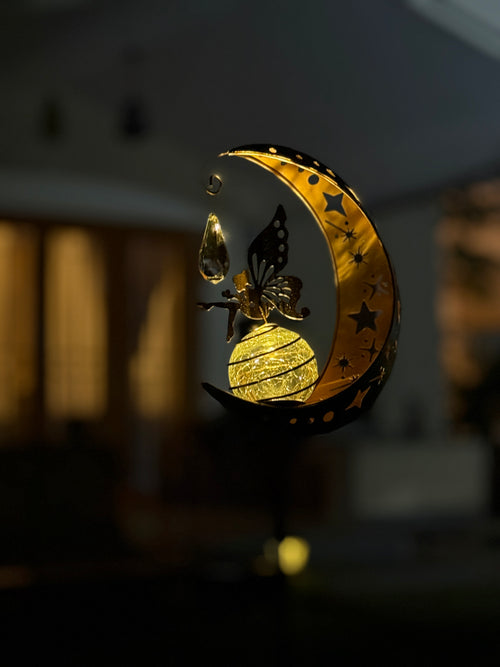 Decorative lamp with a butterfly on a moon-shaped base in Night